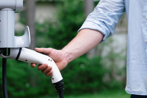 woman holding ev charging port going in car